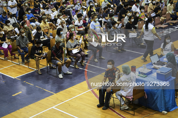 People receive doses of the Pfizer COVID-19 vaccine booster at a vaccination center inside a stadium in Bangkok, Thailand, 03 December 2022....