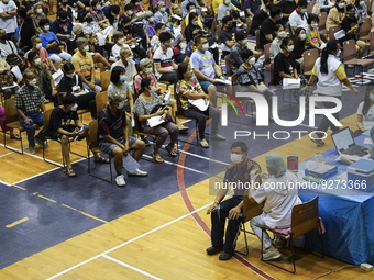 People receive doses of the Pfizer COVID-19 vaccine booster at a vaccination center inside a stadium in Bangkok, Thailand, 03 December 2022....