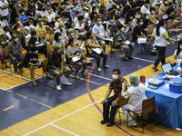 People receive doses of the Pfizer COVID-19 vaccine booster at a vaccination center inside a stadium in Bangkok, Thailand, 03 December 2022....