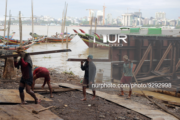 Myanmar workers work at a ship demolition site near Dala jetty in Yangon on December 7, 2022. 