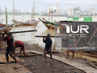 Myanmar workers work at a ship demolition site near Dala jetty in Yangon on December 7, 2022. (