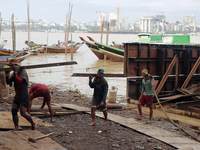 Myanmar workers work at a ship demolition site near Dala jetty in Yangon on December 7, 2022. (