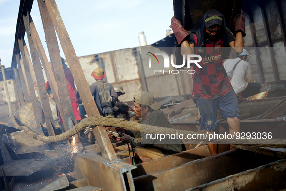 Myanmar workers work at a ship demolition site near Dala jetty in Yangon on December 7, 2022. 