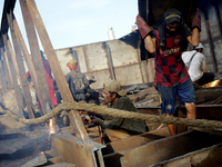 Myanmar workers work at a ship demolition site near Dala jetty in Yangon on December 7, 2022. (