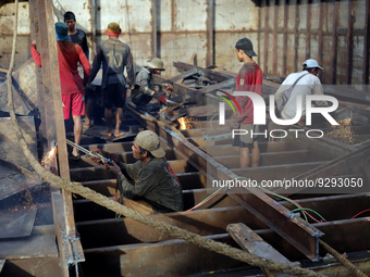 Myanmar workers work at a ship demolition site near Dala jetty in Yangon on December 7, 2022. (