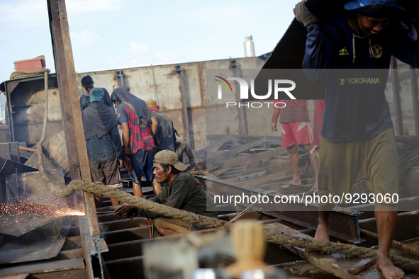 Myanmar workers work at a ship demolition site near Dala jetty in Yangon on December 7, 2022. 