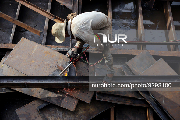 A worker works at a ship demolition site near Dala jetty in Yangon, Myanmar on December 7, 2022. 