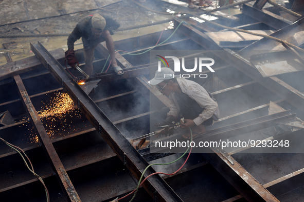 Myanmar workers work at a ship demolition site near Dala jetty in Yangon on December 7, 2022. 