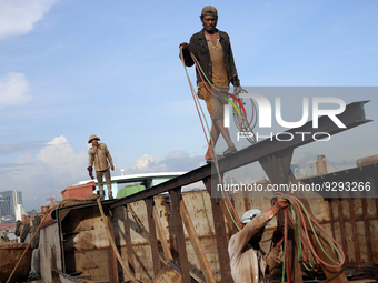 Myanmar workers work at a ship demolition site near Dala jetty in Yangon on December 7, 2022. (