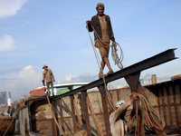 Myanmar workers work at a ship demolition site near Dala jetty in Yangon on December 7, 2022. (