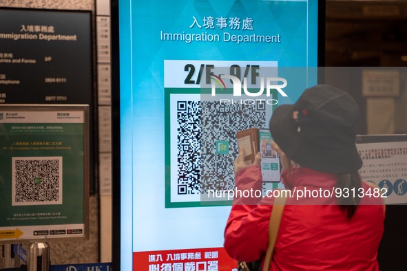 A women scanning a Leave Home Safe QR code display on a screen on December 13, 2022 in Hong Kong, China. The Hong Kong Government announced...