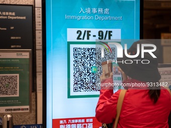 A women scanning a Leave Home Safe QR code display on a screen on December 13, 2022 in Hong Kong, China. The Hong Kong Government announced...