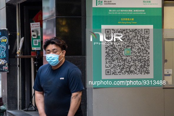 A man walks pass a Leave Home Safe QR code placed on the wall on December 13, 2022 in Hong Kong, China. The Hong Kong Government announced t...