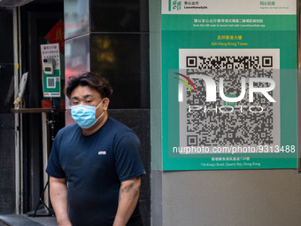 A man walks pass a Leave Home Safe QR code placed on the wall on December 13, 2022 in Hong Kong, China. The Hong Kong Government announced t...