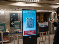 A man scanning a Leave Home Safe QR code display on a screen on December 13, 2022 in Hong Kong, China. The Hong Kong Government announced th...