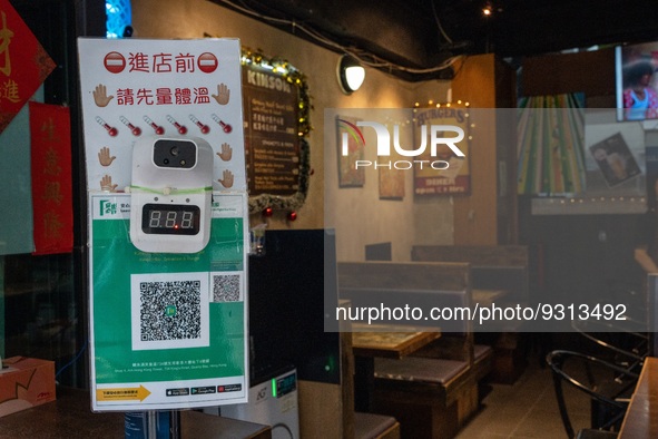 A Thermometers on top of a Leave Home Safe QR code at the entrance of a restaurant on December 13, 2022 in Hong Kong, China. The Hong Kong G...