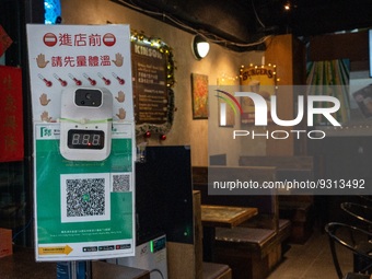 A Thermometers on top of a Leave Home Safe QR code at the entrance of a restaurant on December 13, 2022 in Hong Kong, China. The Hong Kong G...