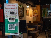 A Thermometers on top of a Leave Home Safe QR code at the entrance of a restaurant on December 13, 2022 in Hong Kong, China. The Hong Kong G...