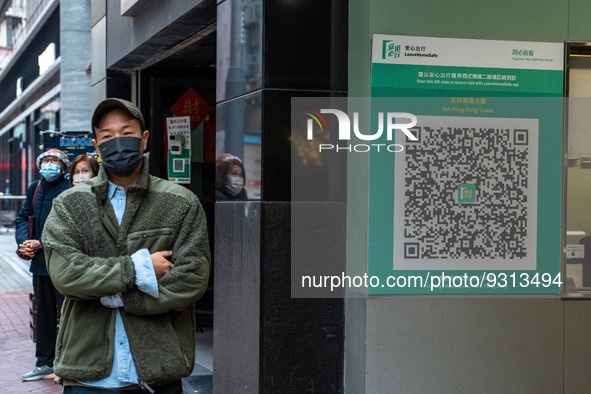 A men walks pass a Leave Home Safe QR Code place on the wall on December 13, 2022 in Hong Kong, China. The Hong Kong Government announced th...