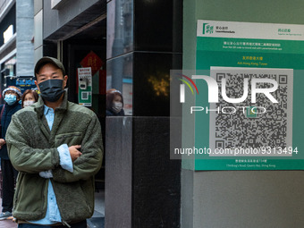 A men walks pass a Leave Home Safe QR Code place on the wall on December 13, 2022 in Hong Kong, China. The Hong Kong Government announced th...