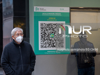 A man walks pass a Leave Home Safe QR code placed on the wall on December 13, 2022 in Hong Kong, China. The Hong Kong Government announced t...