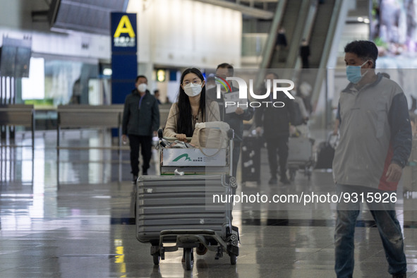 A woman pushing a Luggage trolley inside Terminal 1 at Hong Kong International Airport on December 14, 2022 in Hong Kong, China. The Hong Ko...