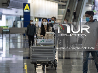 A woman pushing a Luggage trolley inside Terminal 1 at Hong Kong International Airport on December 14, 2022 in Hong Kong, China. The Hong Ko...