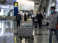 A woman pushing a Luggage trolley inside Terminal 1 at Hong Kong International Airport on December 14, 2022 in Hong Kong, China. The Hong Ko...