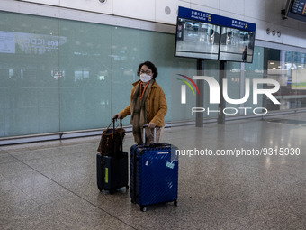 A women with luggages at the arrival hall inside Terminal 1 at Hong Kong International Airport on December 14, 2022 in Hong Kong, China. The...