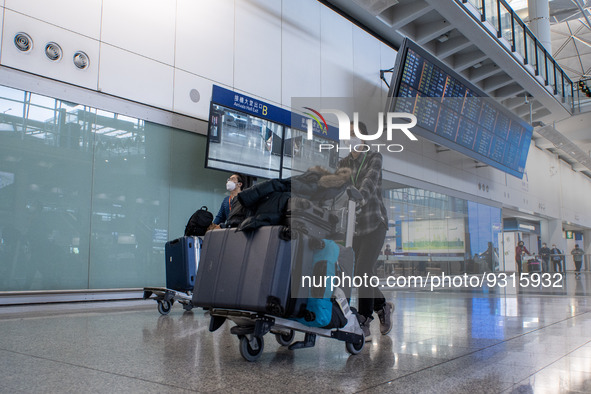 A woman pushing a luggage trolley at the arrival hall inside Terminal 1 at Hong Kong International Airport on December 14, 2022 in Hong Kong...