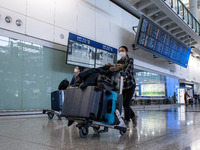 A woman pushing a luggage trolley at the arrival hall inside Terminal 1 at Hong Kong International Airport on December 14, 2022 in Hong Kong...