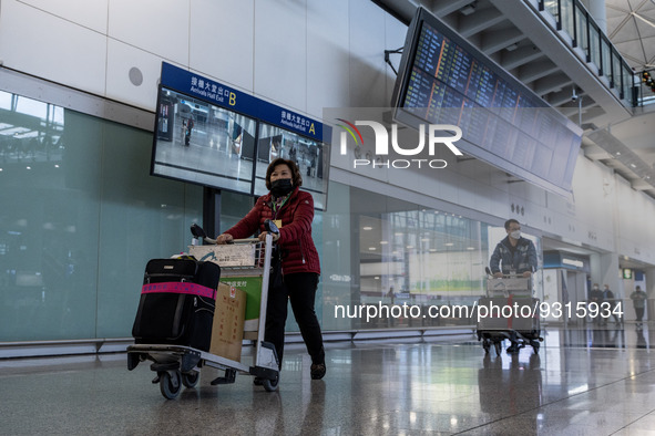 A woman pushing a luggage trolley at the arrival hall inside Terminal 1 at Hong Kong International Airport on December 14, 2022 in Hong Kong...