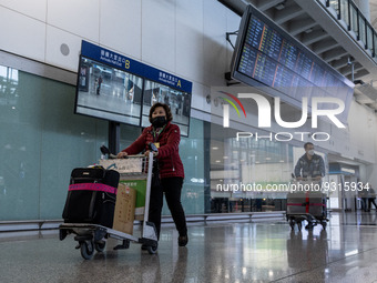 A woman pushing a luggage trolley at the arrival hall inside Terminal 1 at Hong Kong International Airport on December 14, 2022 in Hong Kong...