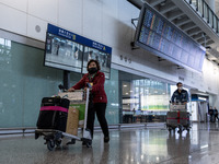 A woman pushing a luggage trolley at the arrival hall inside Terminal 1 at Hong Kong International Airport on December 14, 2022 in Hong Kong...