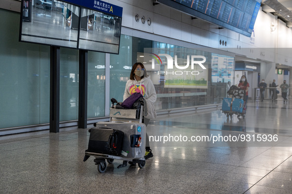 A woman pushing a luggage trolley at the arrival hall inside Terminal 1 at Hong Kong International Airport on December 14, 2022 in Hong Kong...