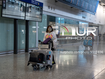 A woman pushing a luggage trolley at the arrival hall inside Terminal 1 at Hong Kong International Airport on December 14, 2022 in Hong Kong...