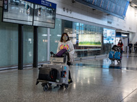 A woman pushing a luggage trolley at the arrival hall inside Terminal 1 at Hong Kong International Airport on December 14, 2022 in Hong Kong...