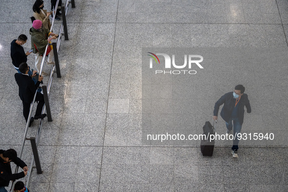 A man with a luggage bag at the arrival hall inside Terminal 1 at Hong Kong International Airport on December 14, 2022 in Hong Kong, China....