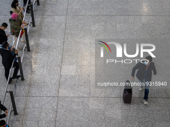 A man with a luggage bag at the arrival hall inside Terminal 1 at Hong Kong International Airport on December 14, 2022 in Hong Kong, China....