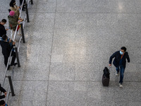 A man with a luggage bag at the arrival hall inside Terminal 1 at Hong Kong International Airport on December 14, 2022 in Hong Kong, China....