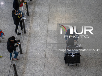 A man pushing a luggage trolley at the arrival hall inside Terminal 1 at Hong Kong International Airport on December 14, 2022 in Hong Kong,...