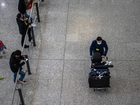 A man pushing a luggage trolley at the arrival hall inside Terminal 1 at Hong Kong International Airport on December 14, 2022 in Hong Kong,...