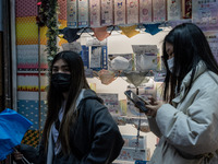 People walking pass a store selling face masks on December 14, 2022 in Hong Kong, China. The Hong Kong Government announced yesterday at a P...