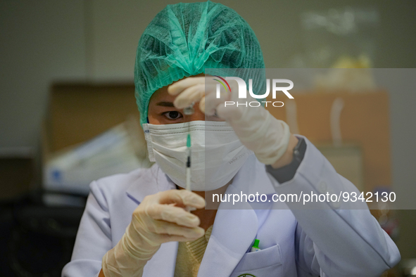 A health worker prepares syringes for administering the COVID-19 vaccine at vaccination site inside the shopping mall in Bangkok on December...