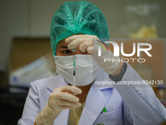 A health worker prepares syringes for administering the COVID-19 vaccine at vaccination site inside the shopping mall in Bangkok on December...