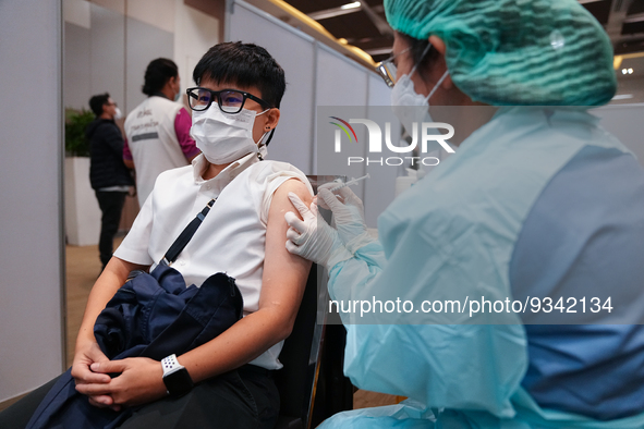 A health worker administers the COVID-19 vaccine to people at vaccination site inside the shopping mall in Bangkok on December 20, 2022 in B...