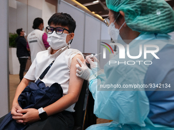 A health worker administers the COVID-19 vaccine to people at vaccination site inside the shopping mall in Bangkok on December 20, 2022 in B...