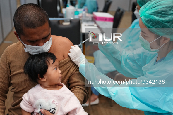 A health worker administers the COVID-19 vaccine to people at vaccination site inside the shopping mall in Bangkok on December 20, 2022 in B...