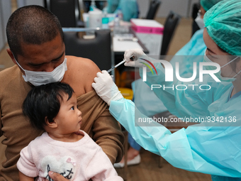 A health worker administers the COVID-19 vaccine to people at vaccination site inside the shopping mall in Bangkok on December 20, 2022 in B...