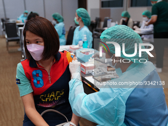 A health worker administers the COVID-19 vaccine to people at vaccination site inside the shopping mall in Bangkok on December 20, 2022 in B...